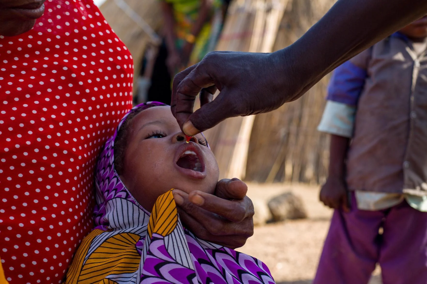A health worker gives a child a drop of vitamin A in Cameroon